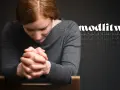 Kobieta z rudymi włosami pochyla głowę w geście modlitwy, składając dłonie. W tle powtarza się słowo "modlitwa", symbolizując nadzieję, że wszystko się ułoży.