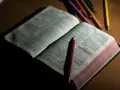 Otwarta Biblia z zaznaczonym fragmentem Psalmu 23. Obok leżą kolorowe kredki, sugerujące refleksję lub modlitwę do archanioła Uriel.