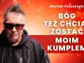 Muniek Staszczyk w okularach, na tle czerwonych świateł. Napis: "Bóg też chciał zostać moim kumplem".