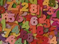 Kolorowe cyfry tworzą tło. Wśród nich wyróżnia się duża, różowa szóstka, symbolizująca 5 rok numerologiczny.