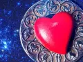 Czerwone serce na tle zodiaku, gdzie widoczny jest symbol Panny i Koziorożca.