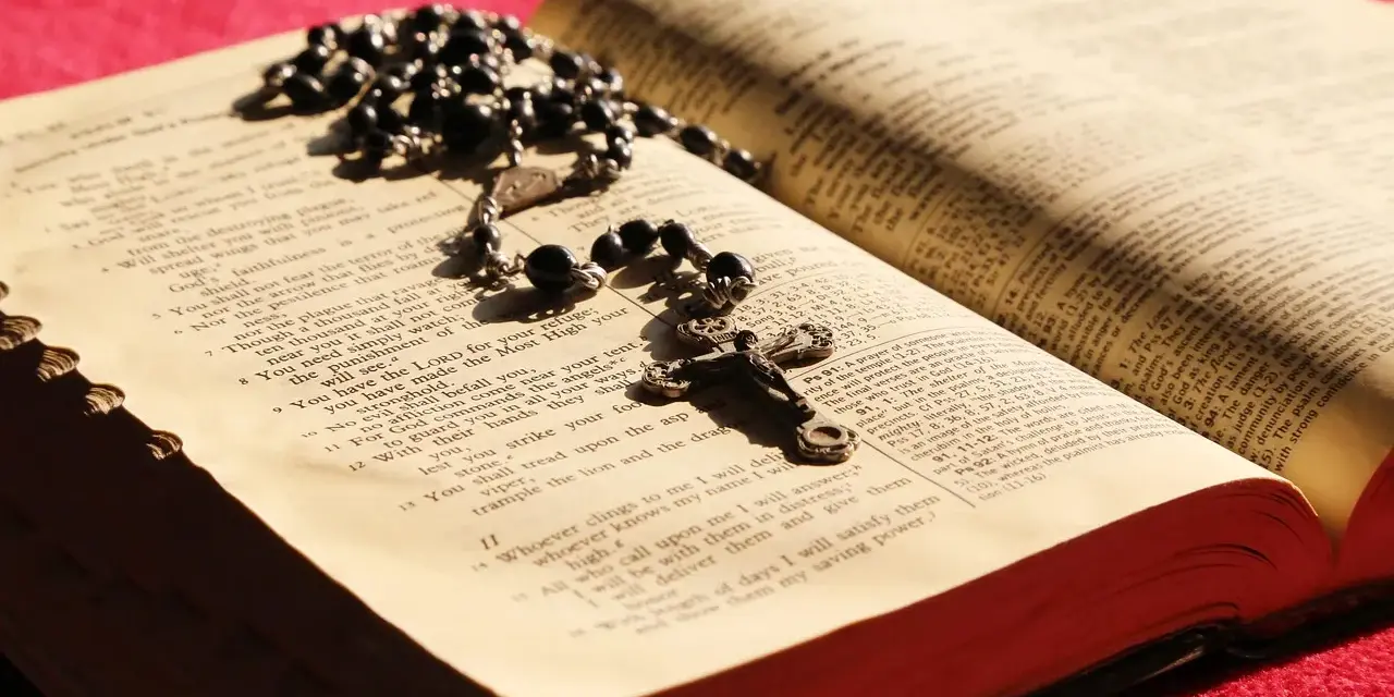 Różaniec i otwarta Biblia, symbol codzienna modlitwa do niepokalanej.