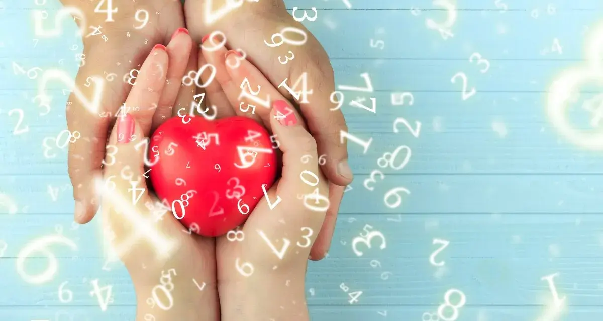 Dłonie trzymają czerwone serce, otoczone liczbami. Numerologia 5 i 11 symbolizuje harmonię i duchowość.