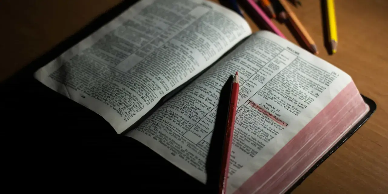 Otwarta Biblia z zaznaczonym fragmentem Psalmu 23. Obok leżą kolorowe kredki, sugerujące refleksję lub modlitwę do archanioła Uriel.