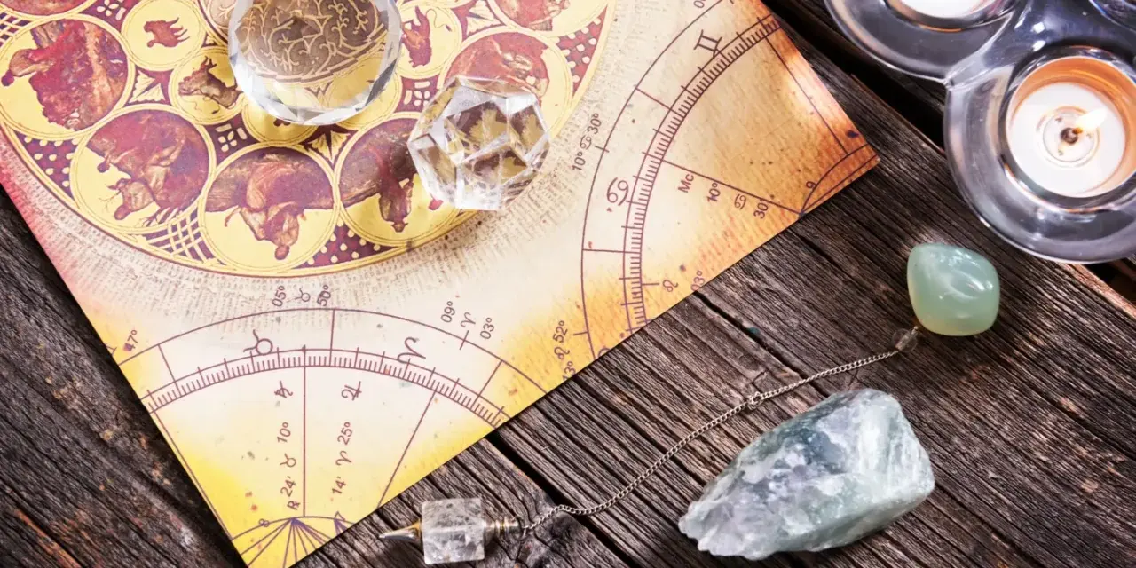 Numerologia 11 z dnia urodzenia. Kryształy, wahadło i świece na tle mapy astrologicznej.