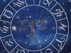 Zodiakalny krąg z symbolem Wagi w centrum. Wokół widoczne inne znaki powietrzne i gwiezdne tło.