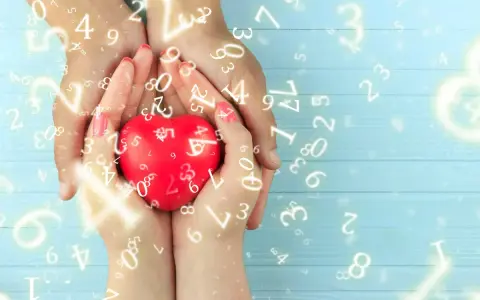 Dłonie trzymają czerwone serce, otoczone liczbami. Numerologia 5 i 11 symbolizuje harmonię i duchowość.