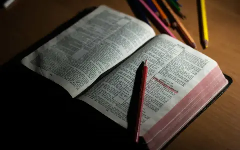 Otwarta Biblia z zaznaczonym fragmentem Psalmu 23. Obok leżą kolorowe kredki, sugerujące refleksję lub modlitwę do archanioła Uriel.