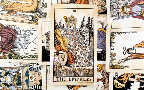 Karta cesarzowa tarot, III Arkanum Wielkie, przedstawia kobietę w koronie, siedzącą na tronie, otoczoną symbolami płodności i natury.