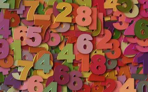 Kolorowe cyfry tworzą tło. Wśród nich wyróżnia się duża, różowa szóstka, symbolizująca 5 rok numerologiczny.