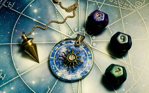 Wahadło i kostki z symbolami planet na tle wykresu astrologicznego. Znaki zodiaku i żywioły w magicznym układzie.