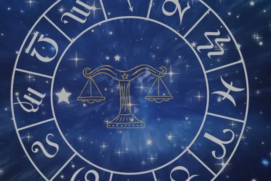 Zodiakalny krąg z symbolem Wagi w centrum. Wokół widoczne inne znaki powietrzne i gwiezdne tło.