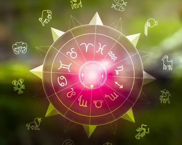 Okrąg zodiaku z symbolami, w tym lew i strzelec, na tle zieleni.