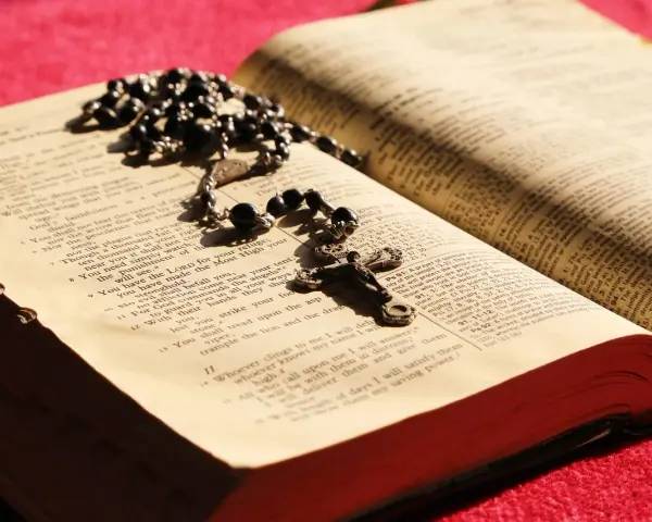 Różaniec i otwarta Biblia, symbol codzienna modlitwa do niepokalanej.