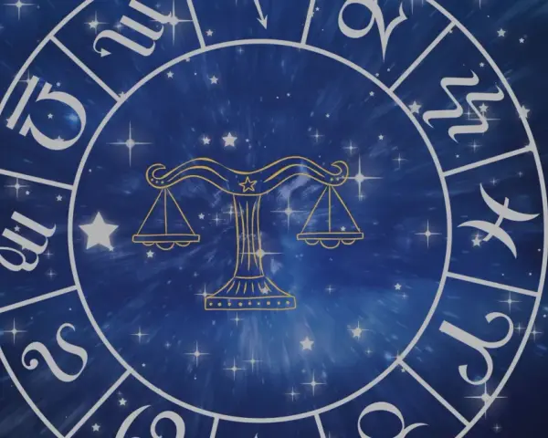 Zodiakalny krąg z symbolem Wagi w centrum. Wokół widoczne inne znaki powietrzne i gwiezdne tło.