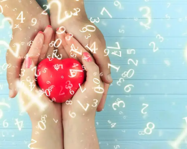 Dłonie trzymają czerwone serce, otoczone liczbami. Numerologia 5 i 11 symbolizuje harmonię i duchowość.