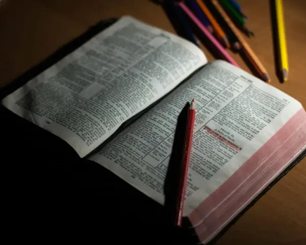 Otwarta Biblia z zaznaczonym fragmentem Psalmu 23. Obok leżą kolorowe kredki, sugerujące refleksję lub modlitwę do archanioła Uriel.