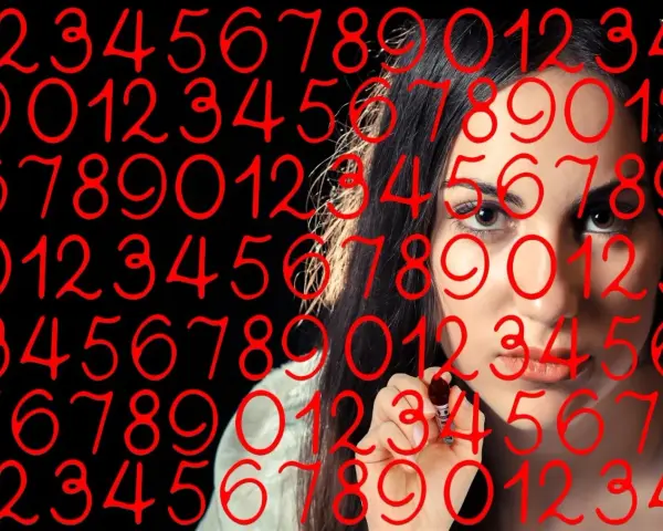 Kobieta pisze cyfry, wśród których widać numerologiczną 4 i 9.