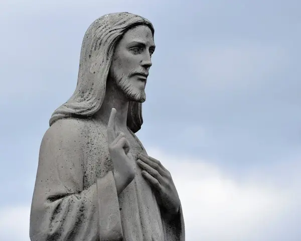 Kamienna rzeźba Jezusa z podniesionym palcem, jakby w geście błogosławieństwa lub modlitwy o pracę.