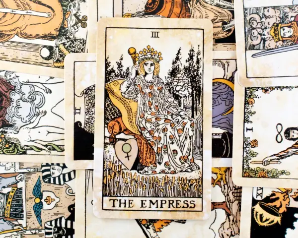 Karta cesarzowa tarot, III Arkanum Wielkie, przedstawia kobietę w koronie, siedzącą na tronie, otoczoną symbolami płodności i natury.
