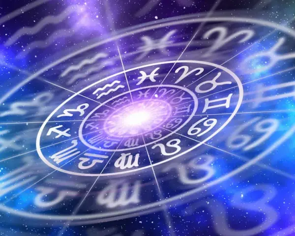 Gwiazdy układają się w krąg zodiaku, gdzie po koziorozcu w zodiaku widać symbole innych znaków na tle kosmicznej mgławicy.