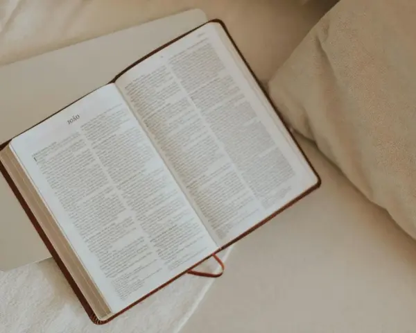 Otwarta Biblia, przygotowana do modlitwy do Jezusa. Tekst na stronach jest czytelny, a całość tworzy spokojną atmosferę.