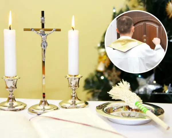 Ksiądz w białej albie puka do drzwi, rozpoczynając poświęcenie domu. Obok świece, krzyż i kropidło.