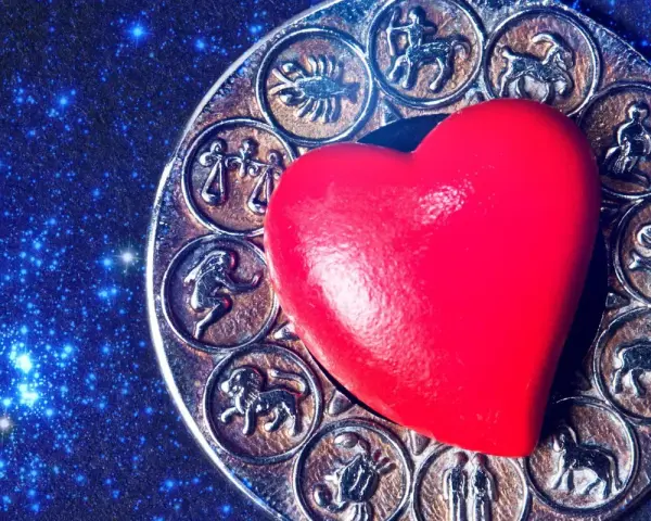 Czerwone serce na tle zodiaku, gdzie widoczny jest symbol Panny i Koziorożca.