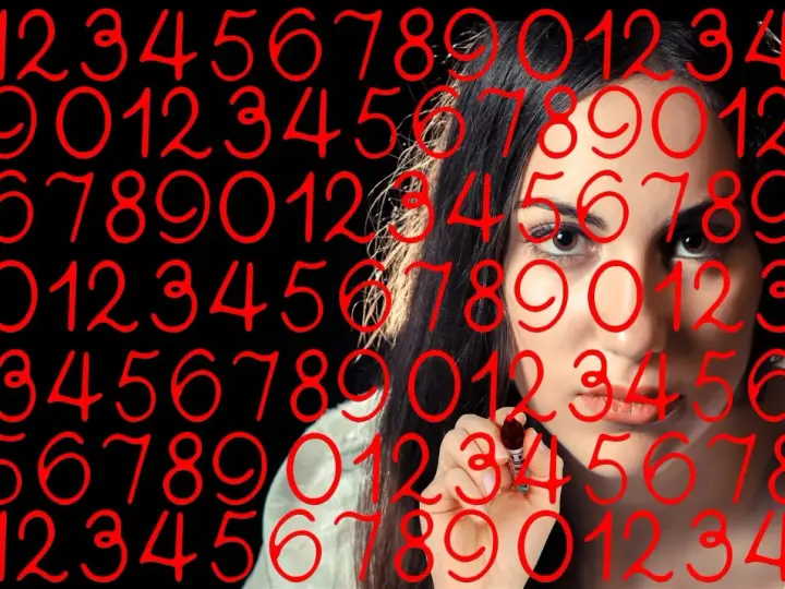 Kobieta pisze cyfry, wśród których widać numerologiczną 4 i 9.