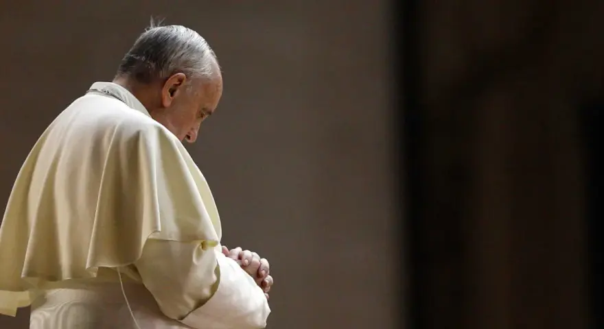Papież Franciszek w białej szacie, z rękami złożonymi do modlitwy do Ojca Świętego.