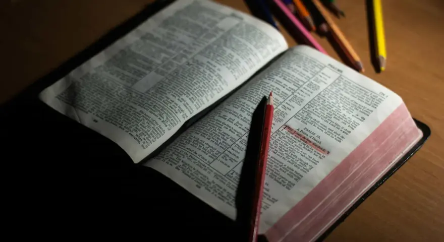 Otwarta Biblia z zaznaczonym fragmentem Psalmu 23. Obok leżą kolorowe kredki, sugerujące refleksję lub modlitwę do archanioła Uriel.