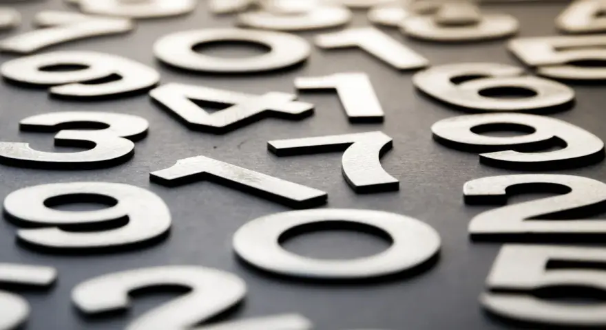 Rozrzucone cyfry tworzą chaos, ale w tym bałaganie można dostrzec numerologiczną trójkę.