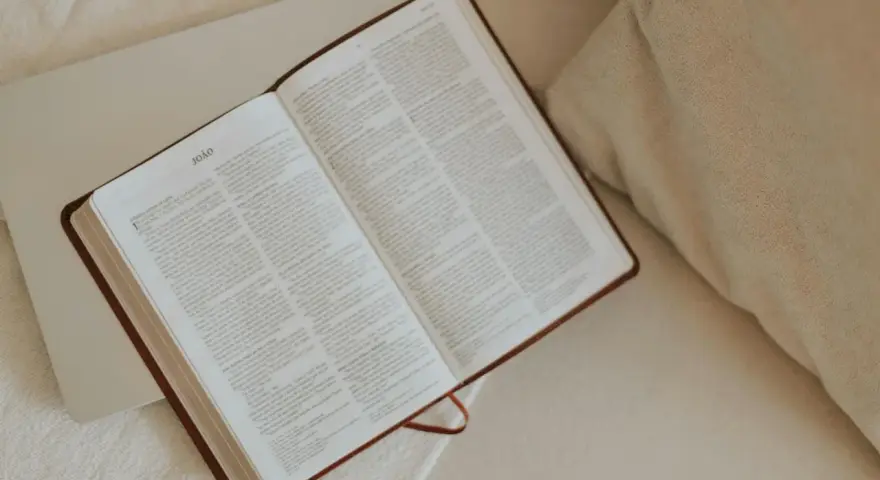 Otwarta Biblia, przygotowana do modlitwy do Jezusa. Tekst na stronach jest czytelny, a całość tworzy spokojną atmosferę.