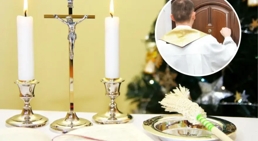 Ksiądz w białej albie puka do drzwi, rozpoczynając poświęcenie domu. Obok świece, krzyż i kropidło.