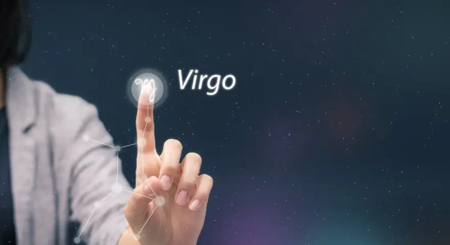 Dłoń dotyka symbolu Panny, gwiazdozbioru Virgo, na tle nocnego nieba.