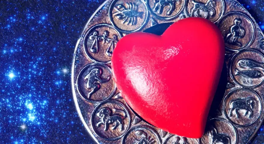 Czerwone serce na tle zodiaku, gdzie widoczny jest symbol Panny i Koziorożca.