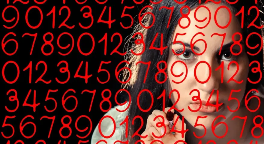 Kobieta pisze liczby, wśród nich numerologiczna 8 i 9.