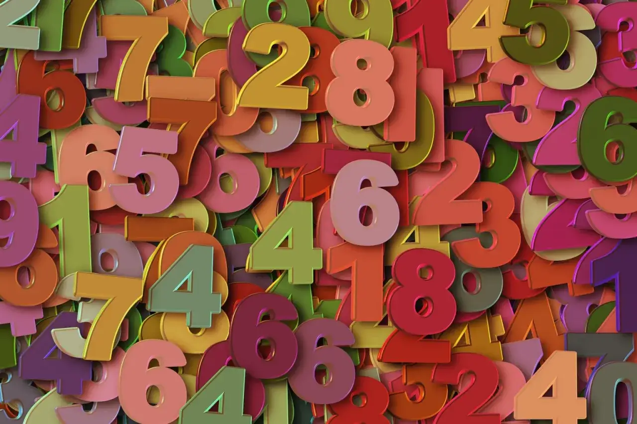 Kolorowe cyfry tworzą tło. Wśr&oacute;d nich wyr&oacute;żnia się duża, r&oacute;żowa sz&oacute;stka, symbolizująca 5 rok numerologiczny.
