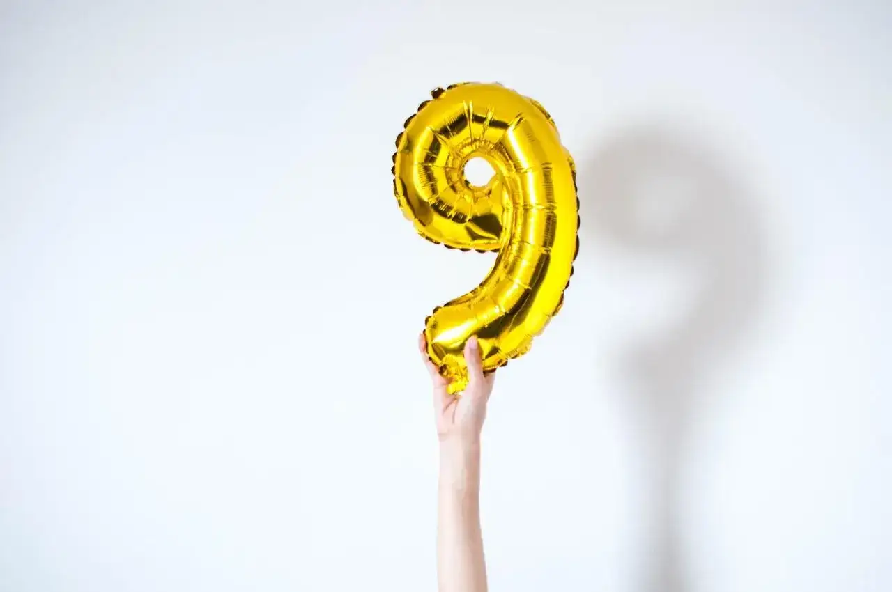 Złoty balon w kształcie cyfry 9, symbolizujący numerologiczną 9 i 4.